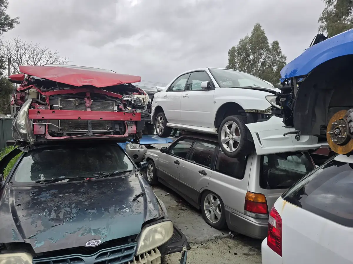 End-of-life vehicles stacked for dismantling and recycling in Perth