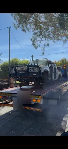 The donor Hilux shell loaded and secured on the tow truck, ready to leave Trent's driveway.