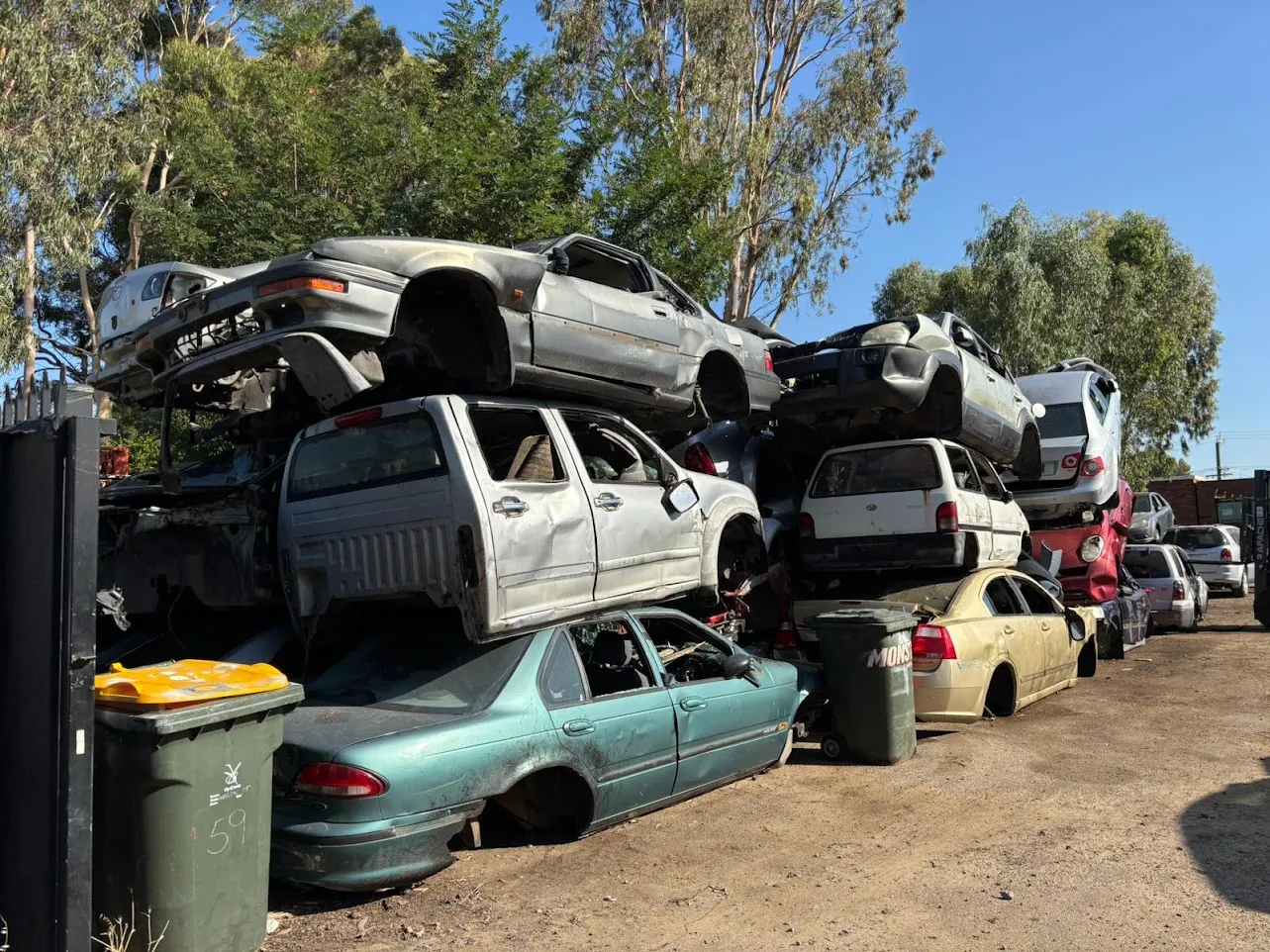 Stacked end-of-life vehicles awaiting depollution at the Midland Wreckers yard in Bellevue, Perth.